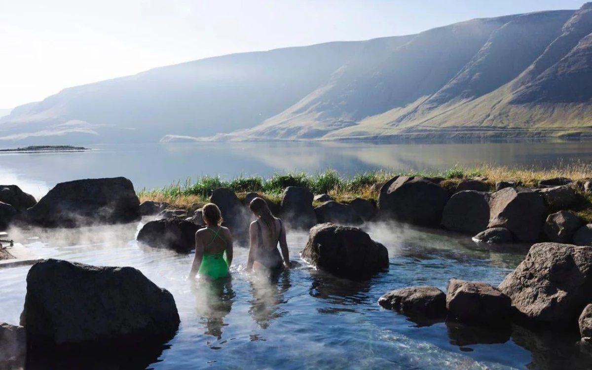 Dampf steigt aus geothermalem Wasser in einem Tal in Island auf
